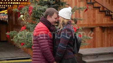 快乐的年轻夫妇在<strong>圣诞</strong>市场上尽情欢乐和亲吻。 男人和女人在<strong>一起</strong>度<strong>过</strong>时光